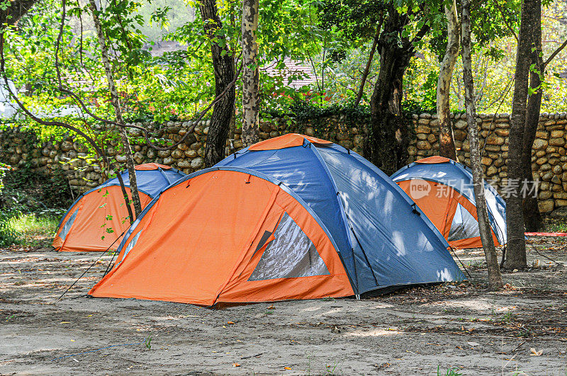 Orange and blue camping tents among trees in Köprülü Canyon national park